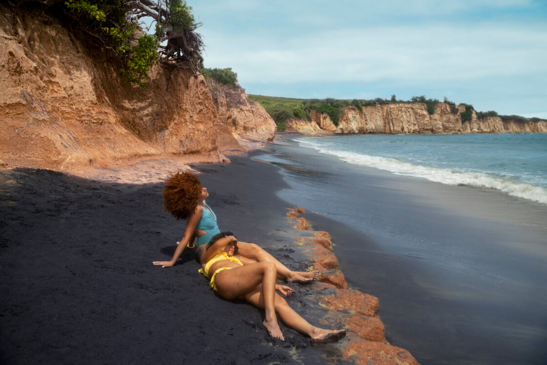 Two women lay on the beach together in Puerto Rico.