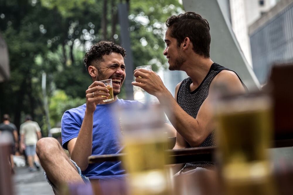 Two men drink beer together