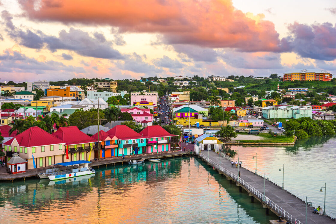 St. John's, Antigua port and skyline at dusk. The waterfront buildings are vibrant and colorful