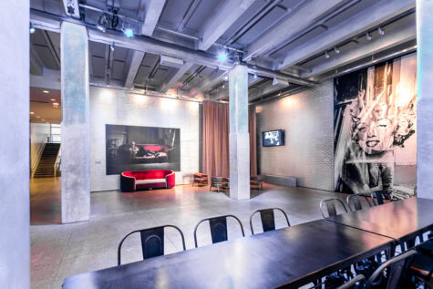 The entrance space to the Andy Warhol museum with a long table in the foreground and two pillars flanking a red couch in the background.