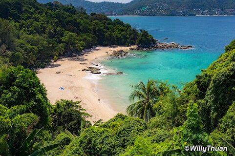 Coastline with bright teal waters surrounded by tropical jungle. Photo via Willy Thuan