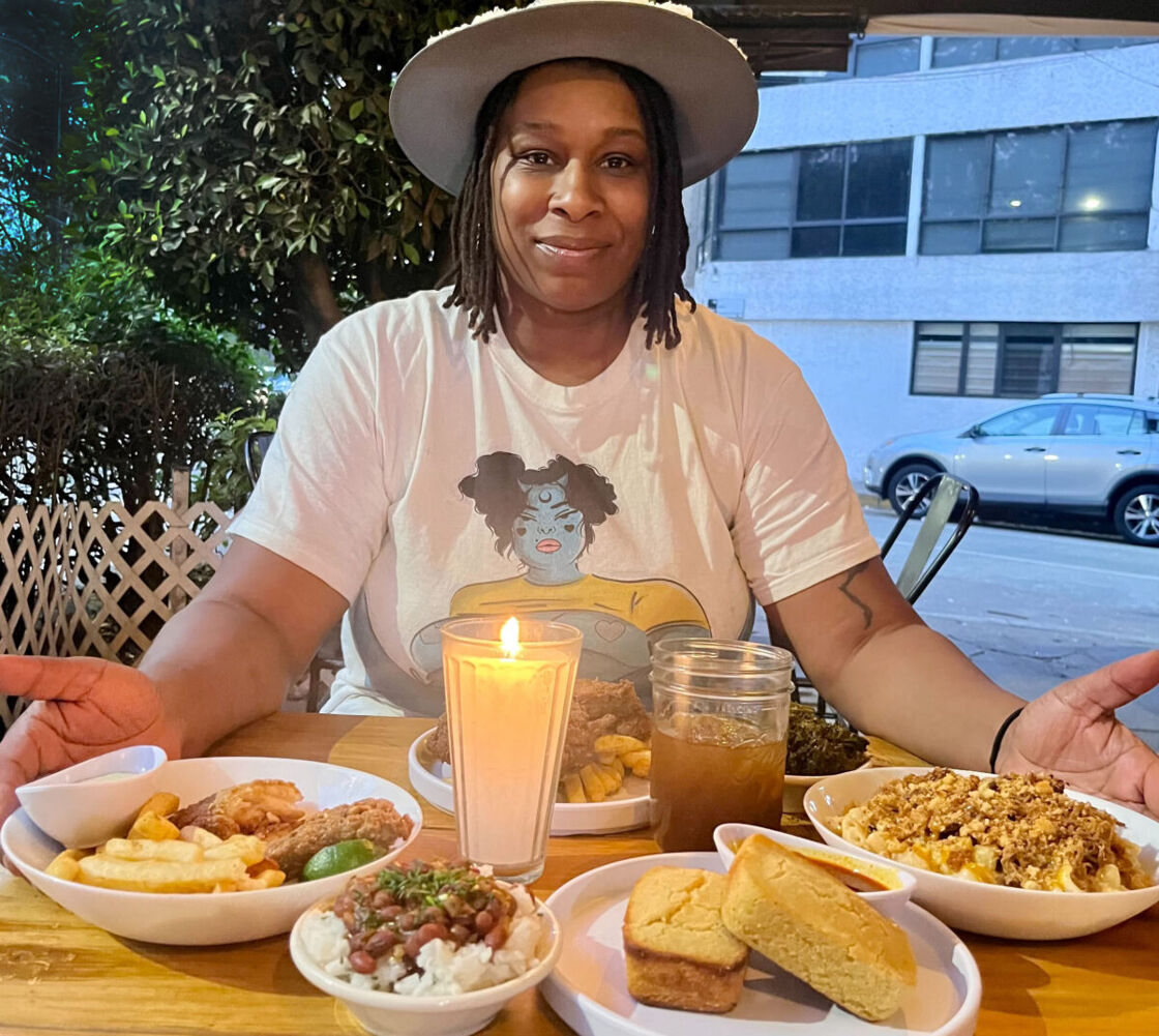 Blaxicocina owner Tiara Darnell poses in front a table full of food