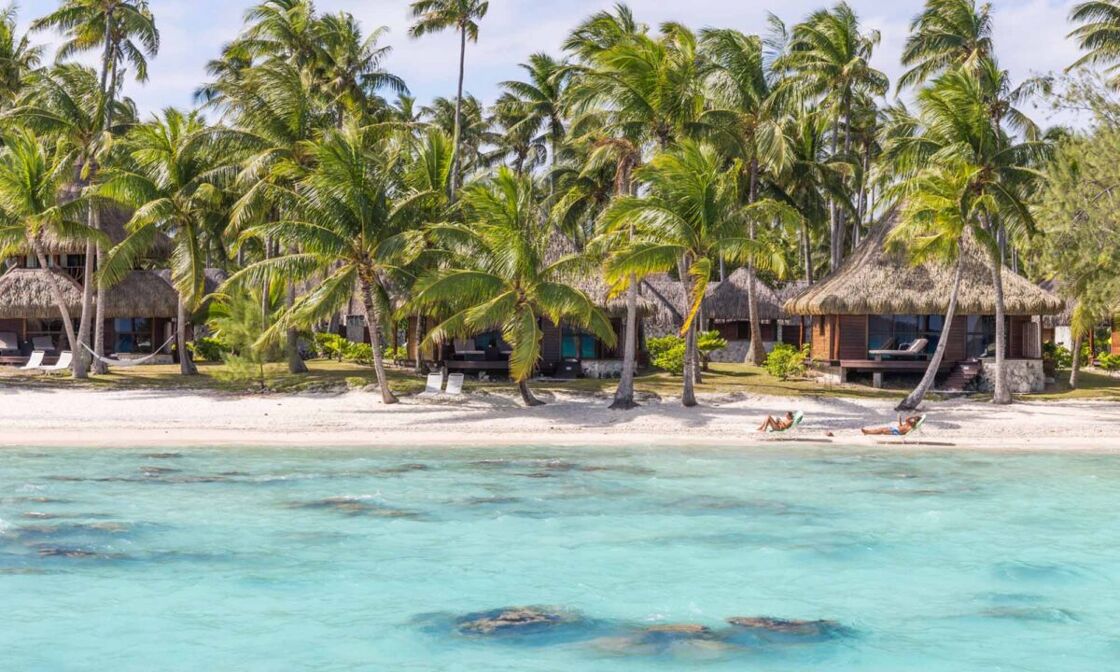 Gorgeous beach bungalows surrounded by crystal clear water. Photo via Tahiti.com