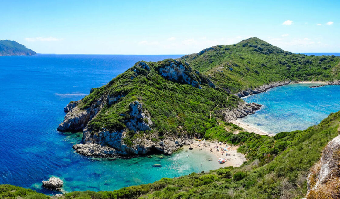 Pristine and lush Greek coastline with beaches and greenery. Photo via Visit Greece
