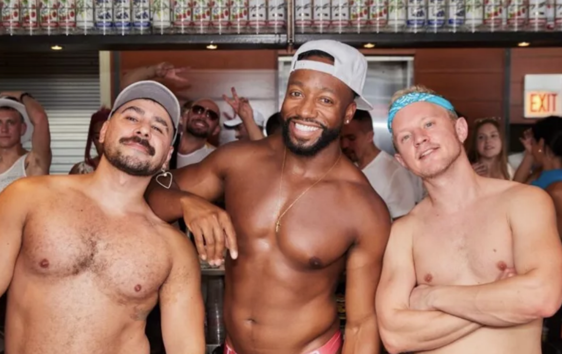 Three muscled shirtless men pose for the camera in Northalsted.