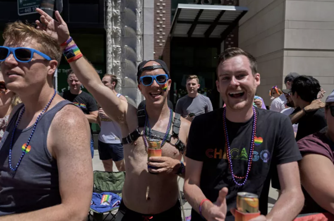 Several men decked out in Pride attire celebrate on a Chicago street.