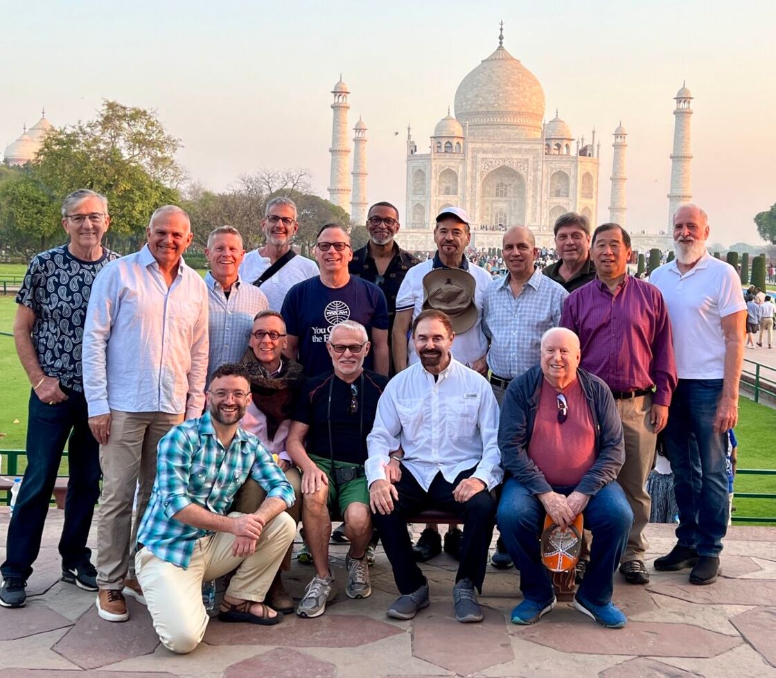 An LGBTQ+ group tour poses in front of the Taj Mahal