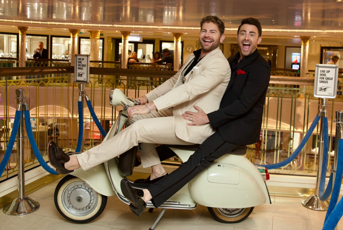Jaymes Vaughan and husband, Jonathan Bennett, pose on a Vespa scooter on board the Carnival Firenze cruise ship.