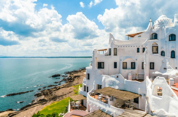 Gorgeous white natural building overlooking a stunning coastline. Photo via shutterstock