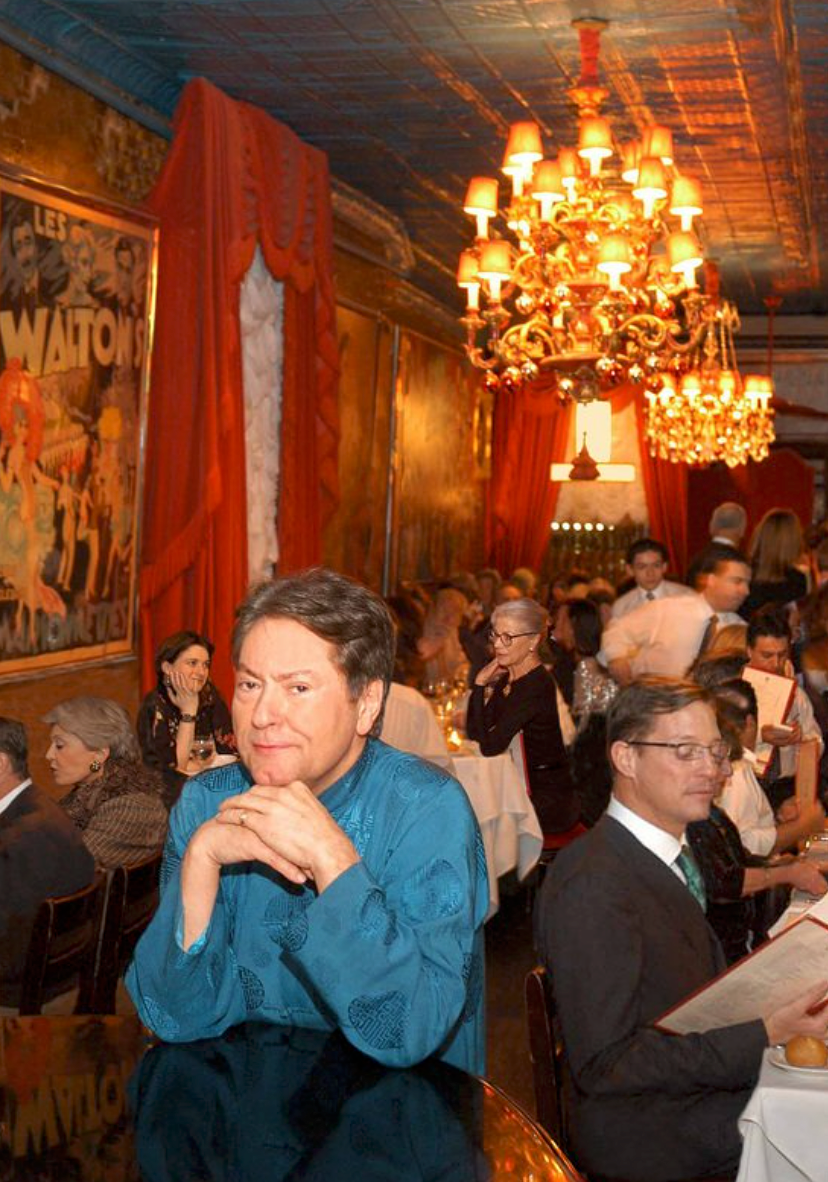 Jean-Claude in a vibrant dark turquoise button down posing inside Chez Josephine. 