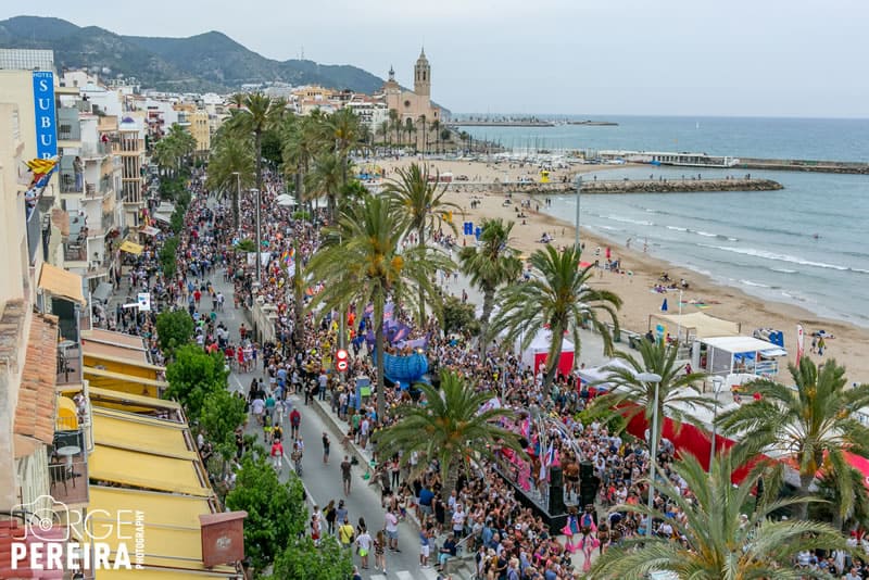 A packed street right next to the ocean. Photo via Sitges Pride