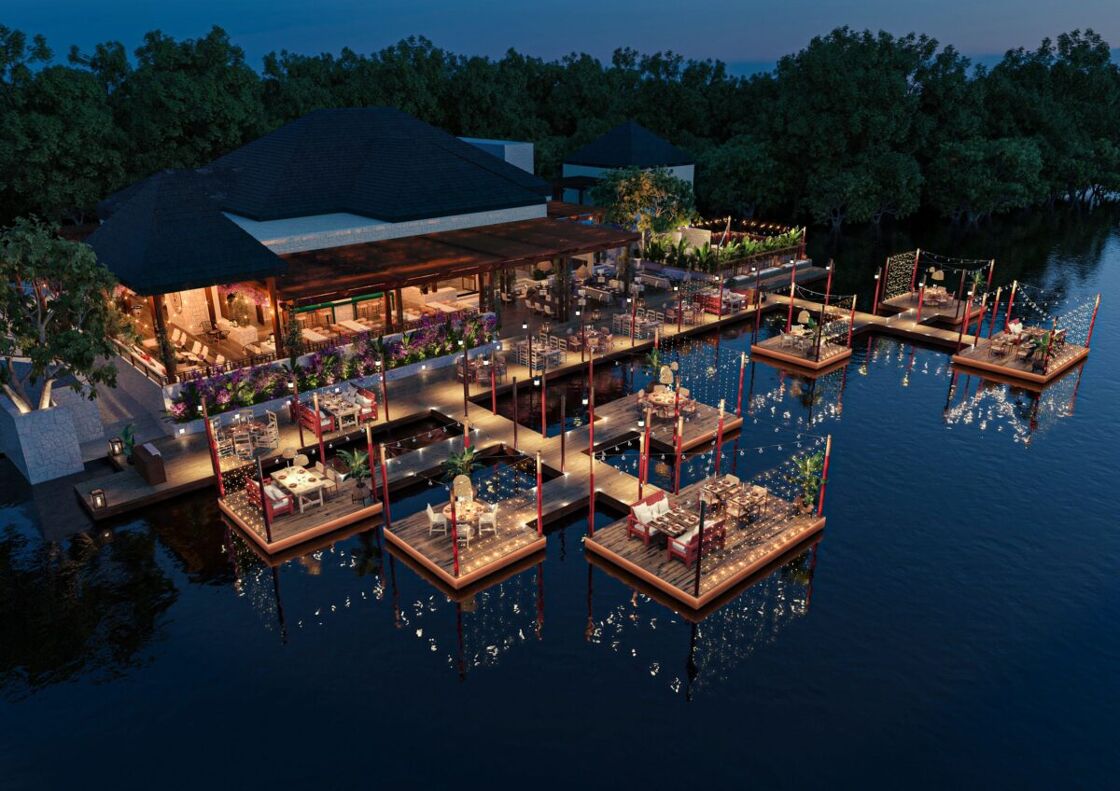 Nighttime overlooking beautiful waterside resort. Glittering lights reflect off the water. Photo via Fairmont Mayakoba