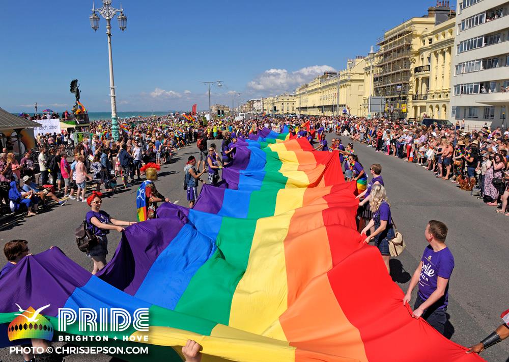 Giant Pride flag is walked down the street during the Brighton Pride Parade