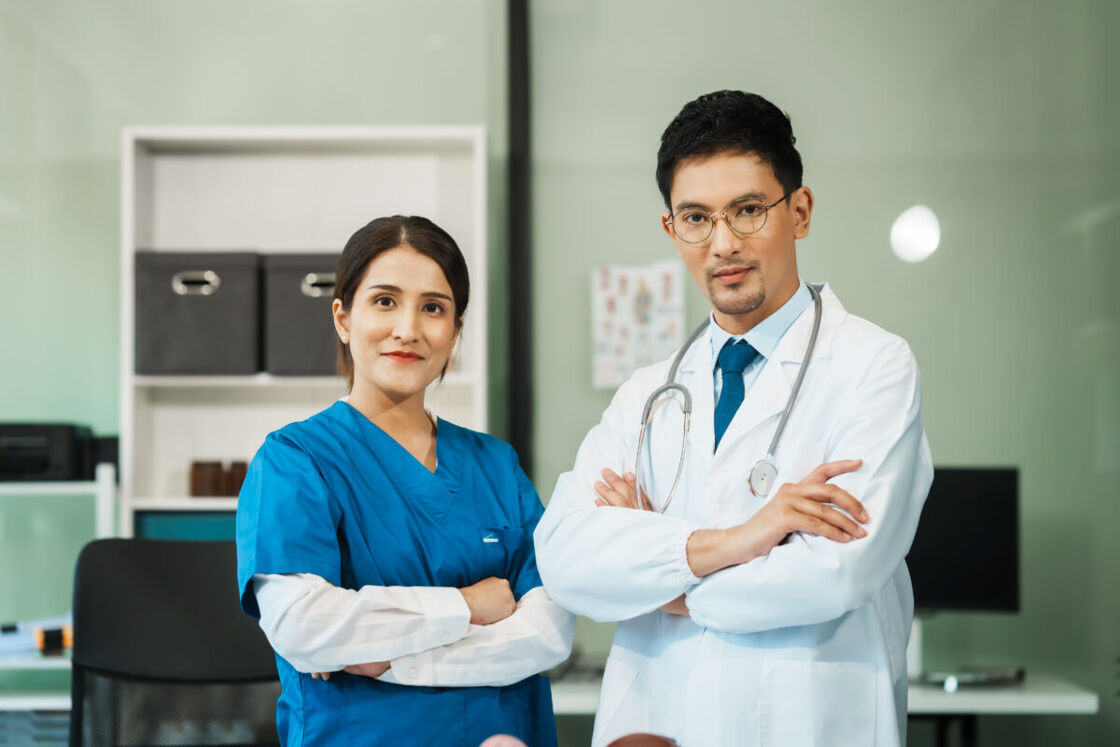 A nurse and doctor stand with arms crossed