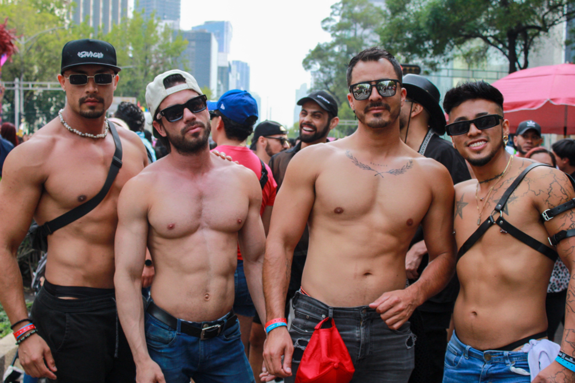 Four shirtless men pose for the camera
