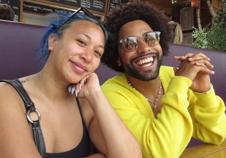 A Black woman and man sit at a table in Berlin