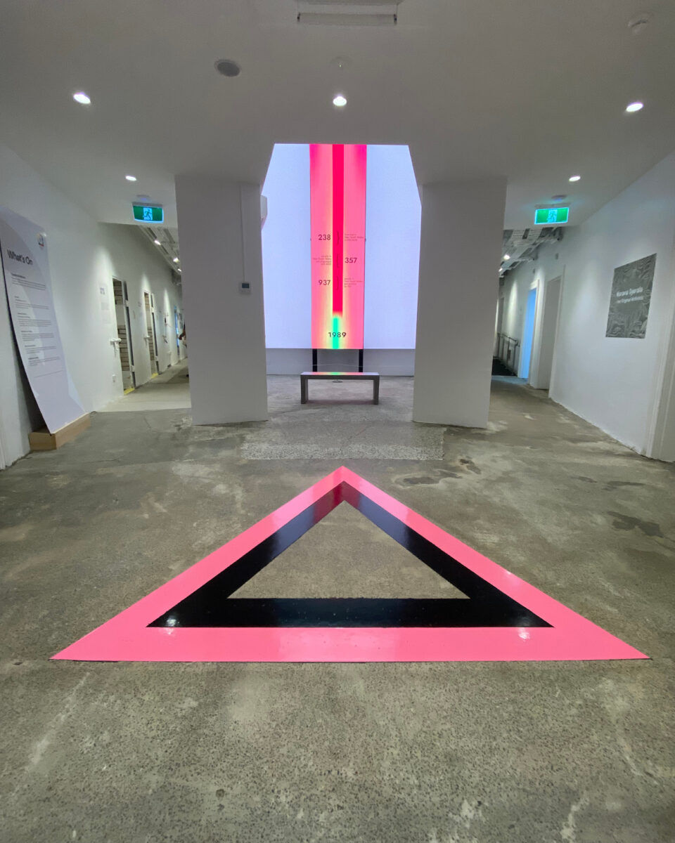 A pink triangle engraved into the marble flooring at Qtopia. 