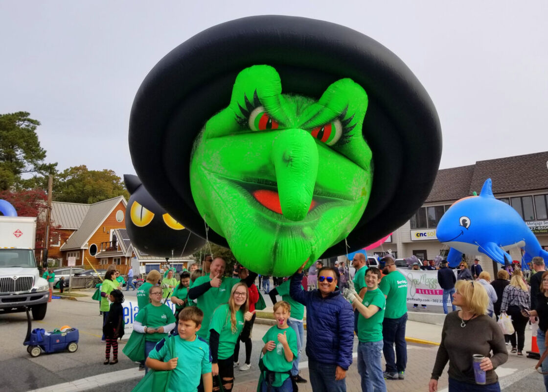 A green witch float on Seawitch Festival parade and the marchers on the street