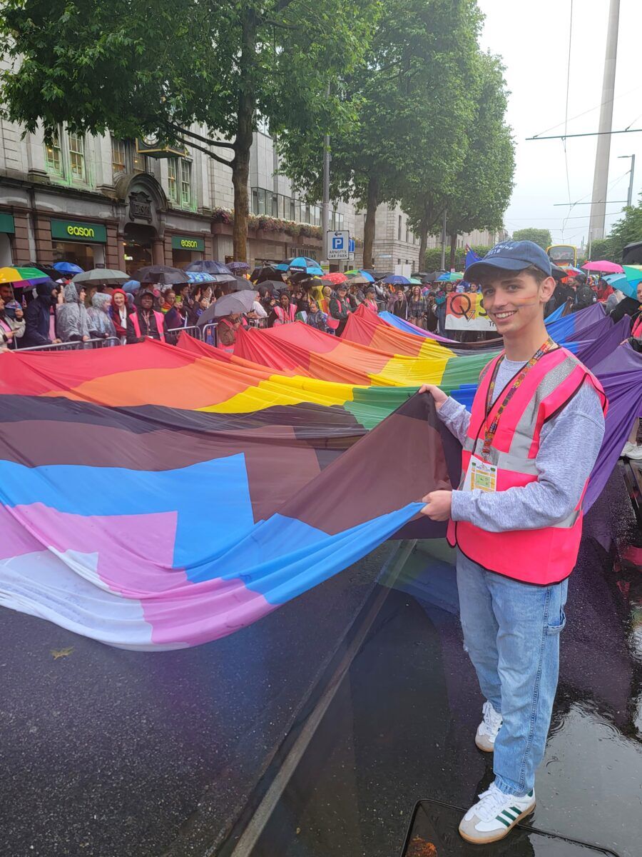 Large LGBTQ+ flag stretched along the street