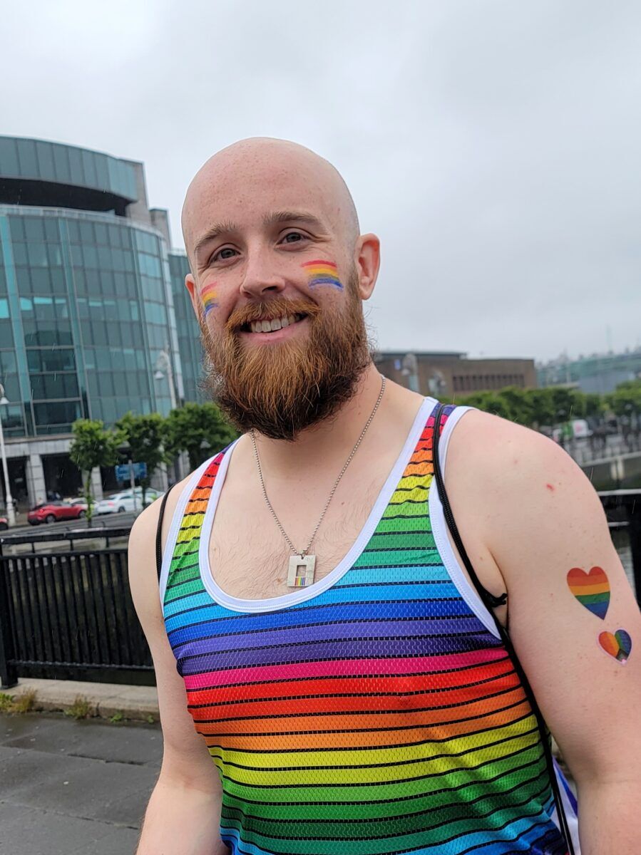 Bald, bearded man in a rainbow tank top