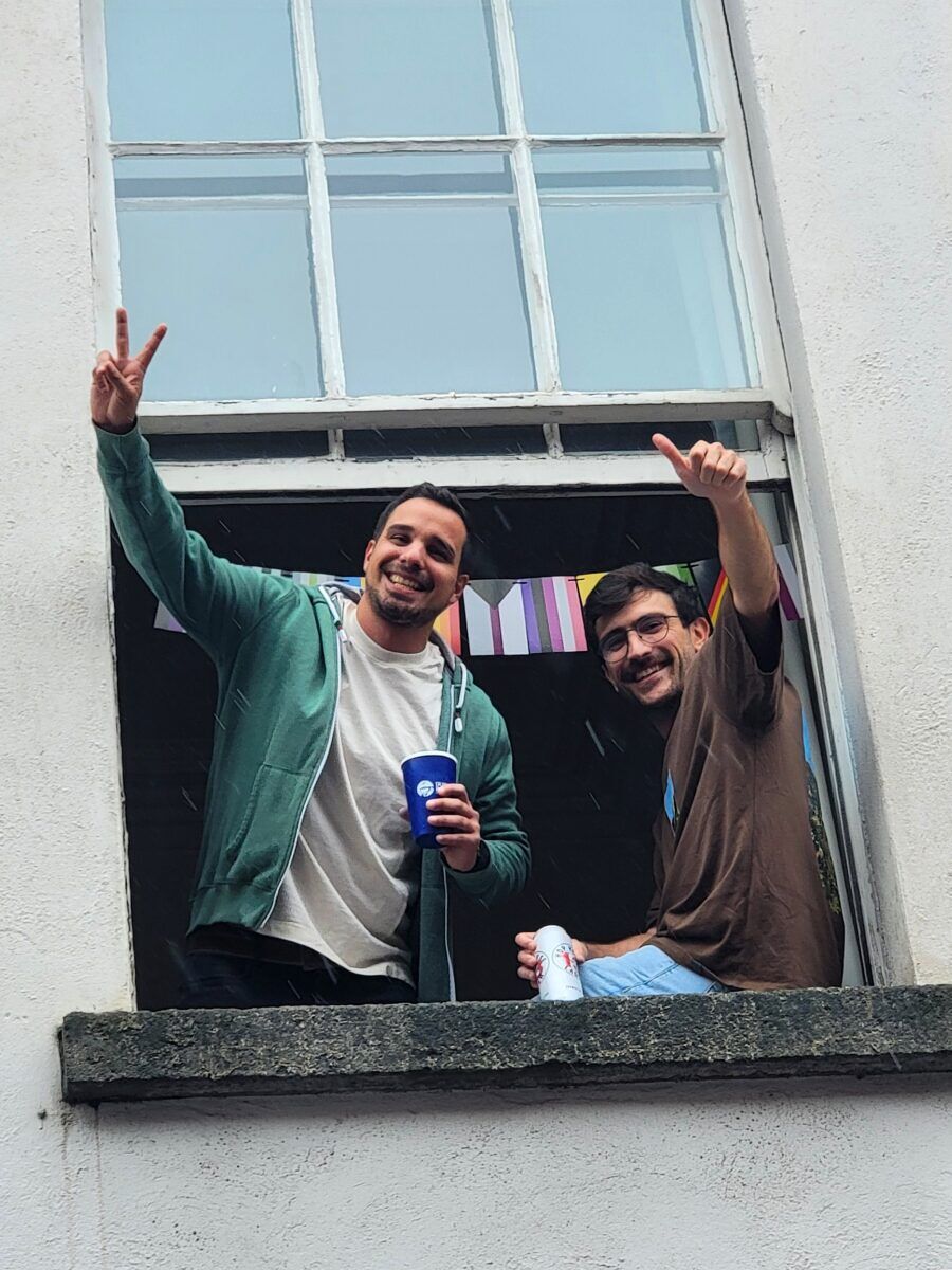 Two men sitting on a window sill