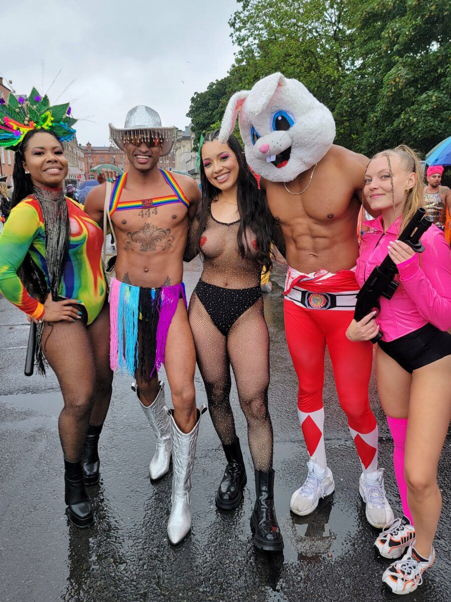 A group of people in various degrees of undress. one wears a bunny head and rocks a 6 pack