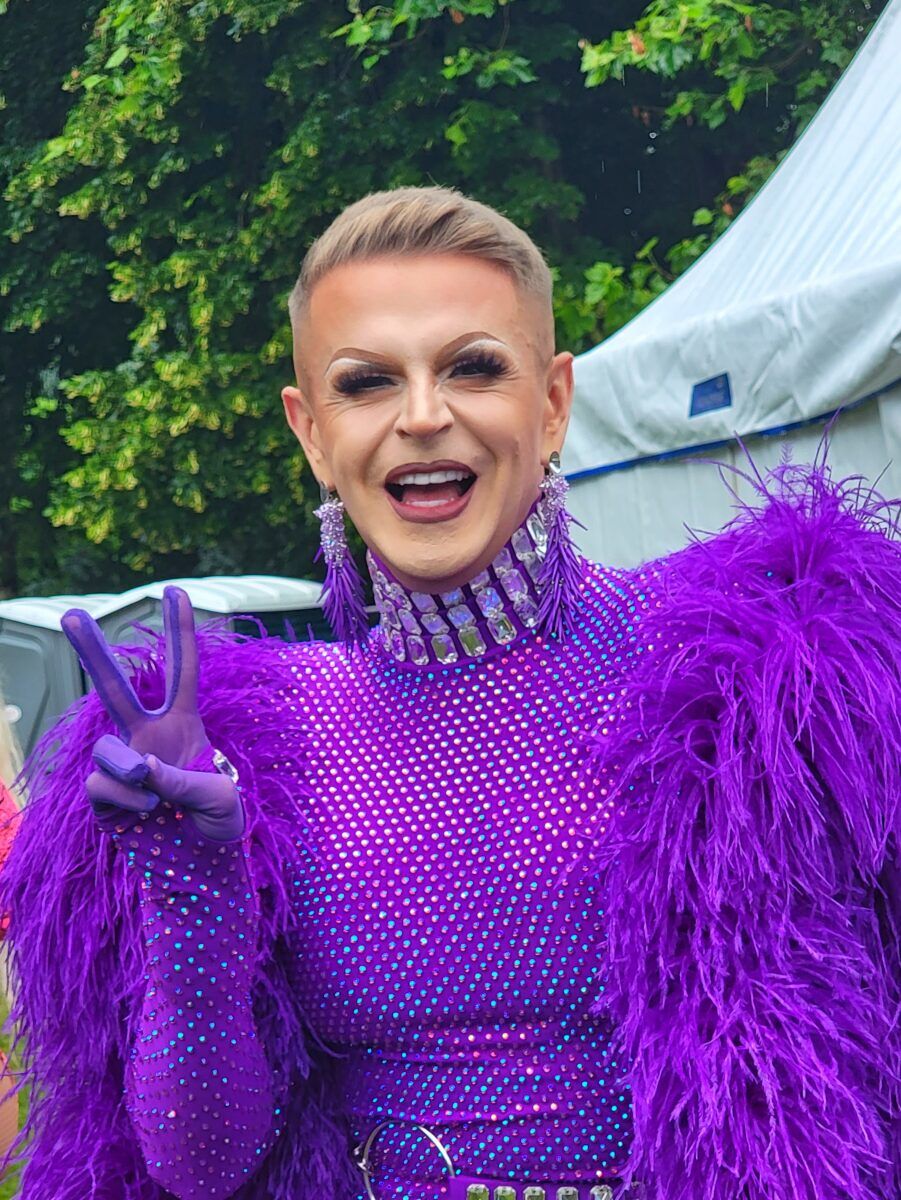 Drag queen in a fabulous purple sequin and feather outfit