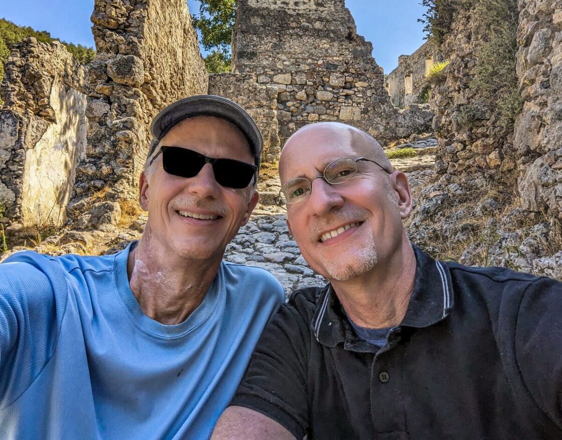Brent and Michael sitting in front of some ruins. Michael Jensen and Brent Hartinger pose in front of stone ruins in Turkey