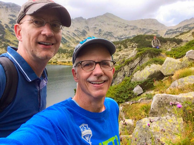 A selfie of he author and his husband hiking in a mountain landscape