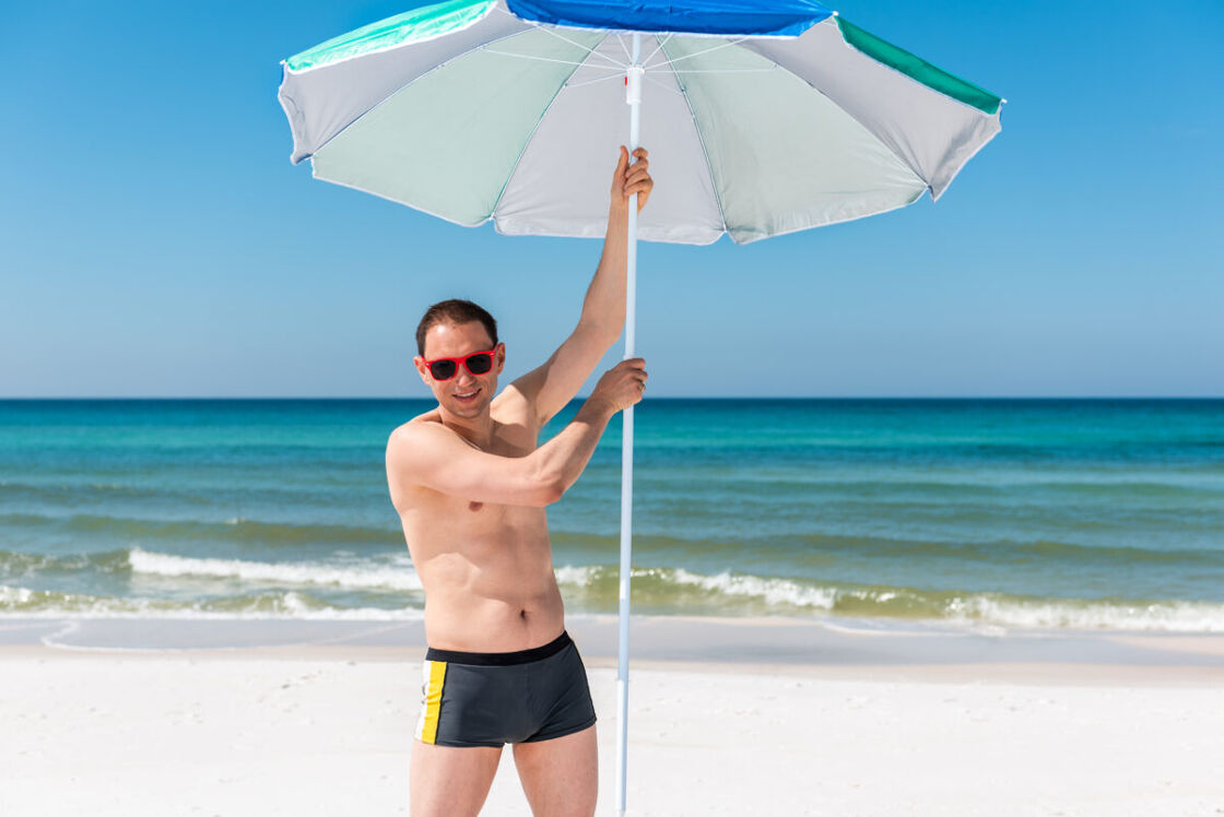Man on the beach with an umbrella
