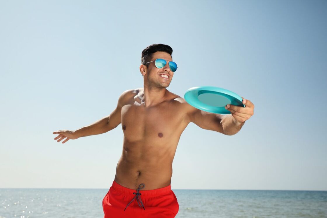 Man throwing frisbee at the beach