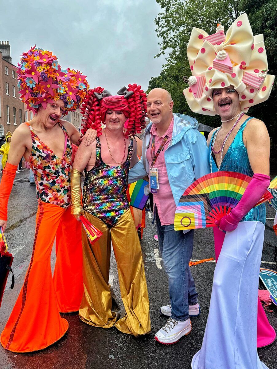 Four fabulously dressed fellows smile at the camera