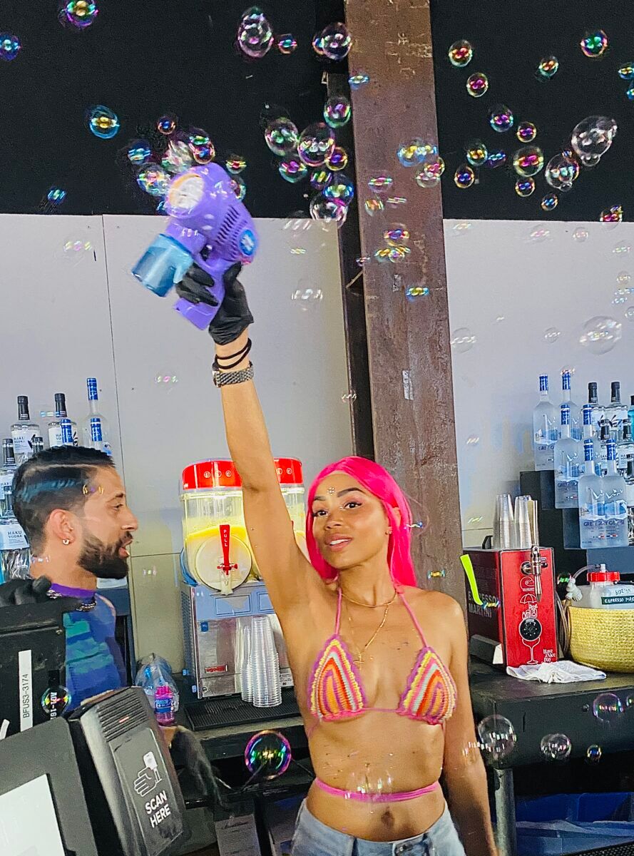 a bartender flaunting her bubble gun at New York Pride
