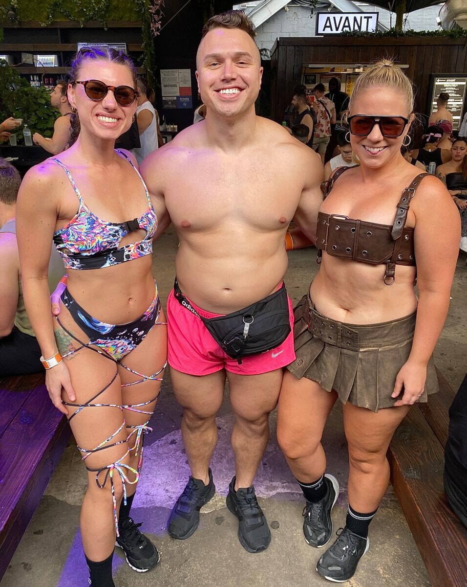 A muscle dude and two girls at New York Pride