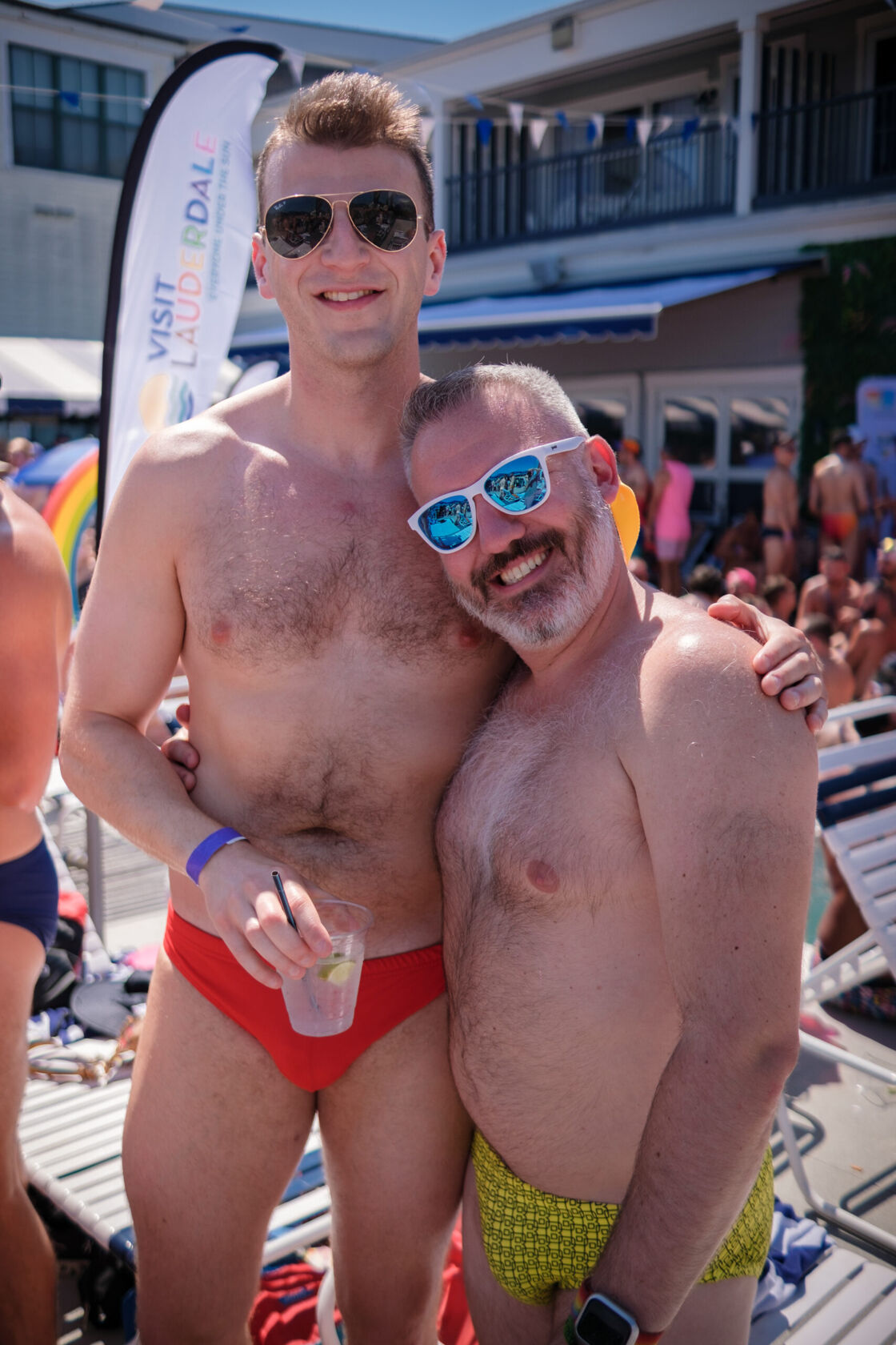 Two men in swimwear smiling for a photo.