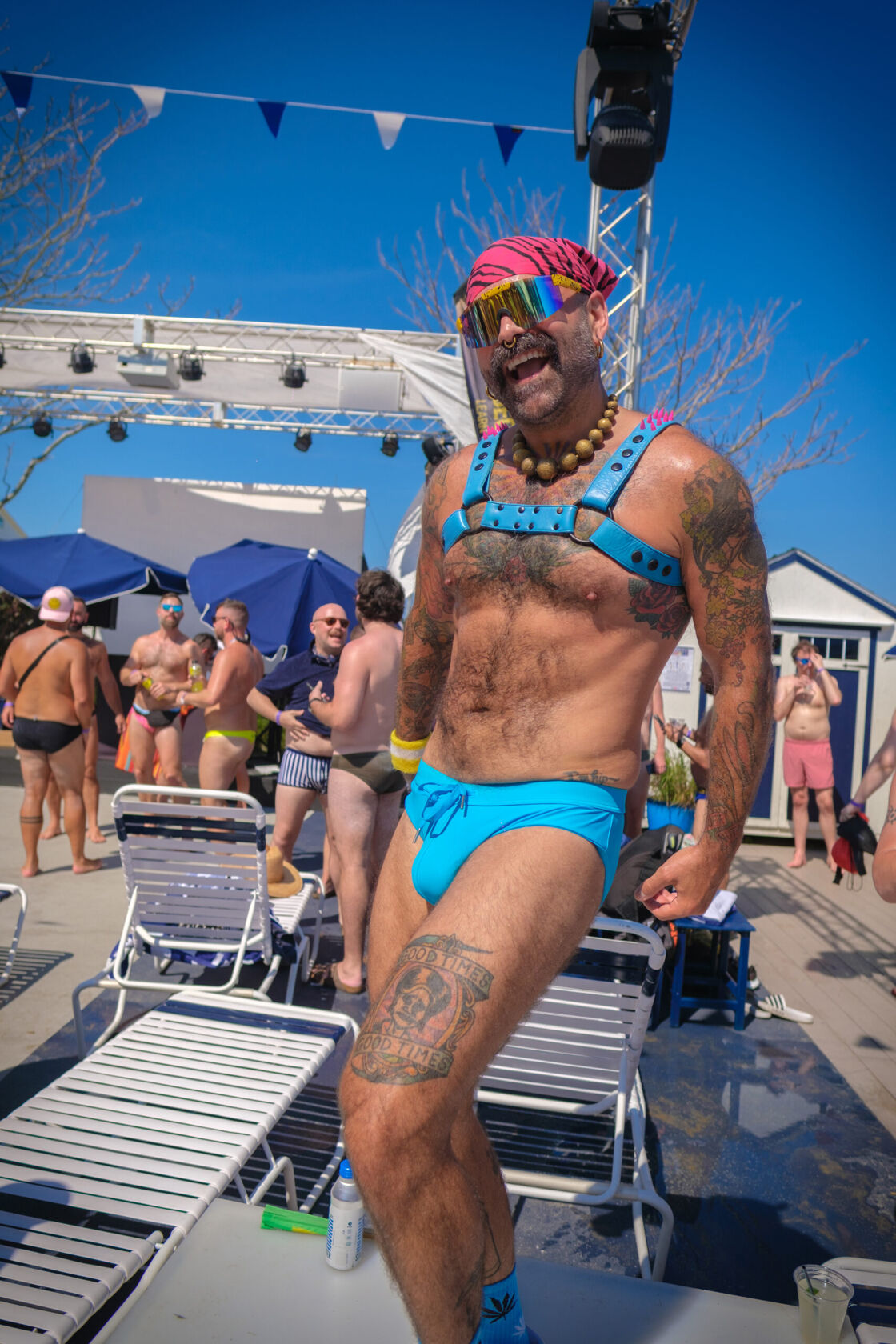 Man in a blue Speedo posing at the poolside.