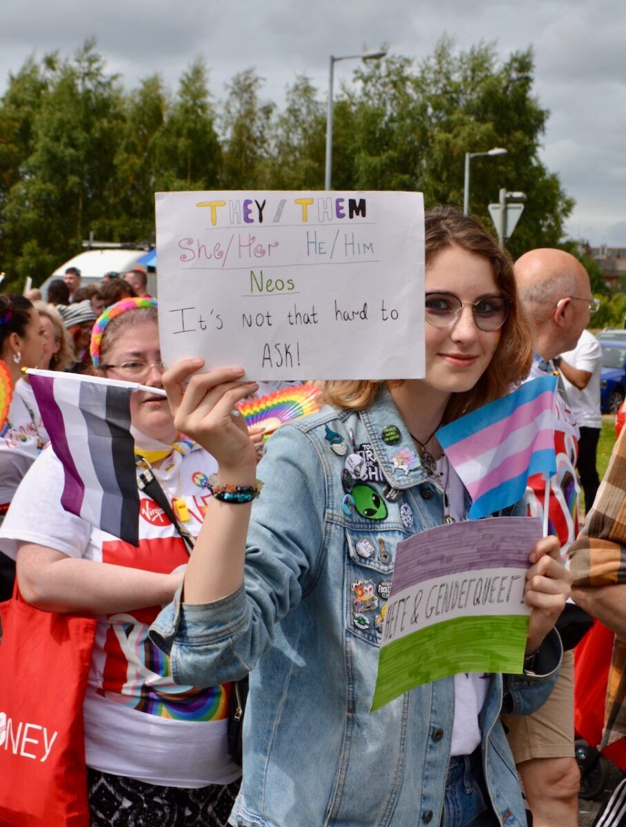 A woman holds a sign that says