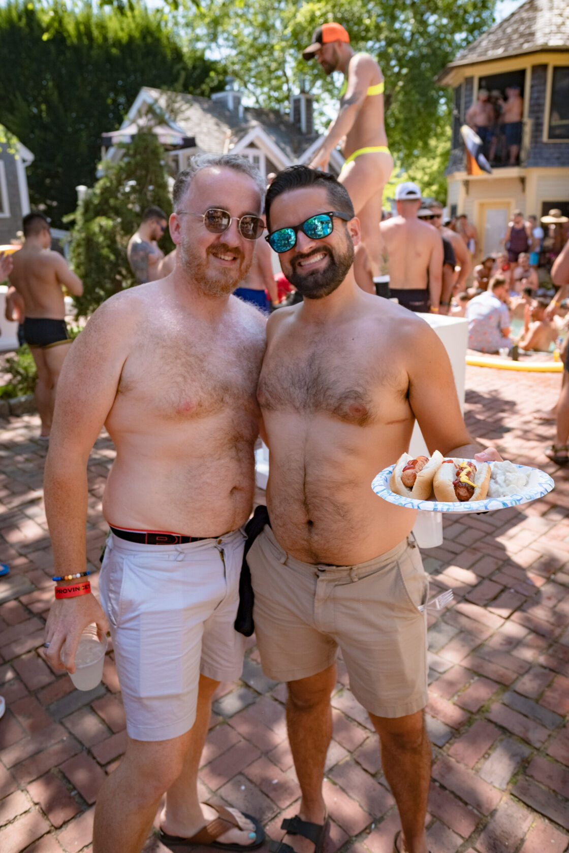 Two men smiling for a photo at a pool party.