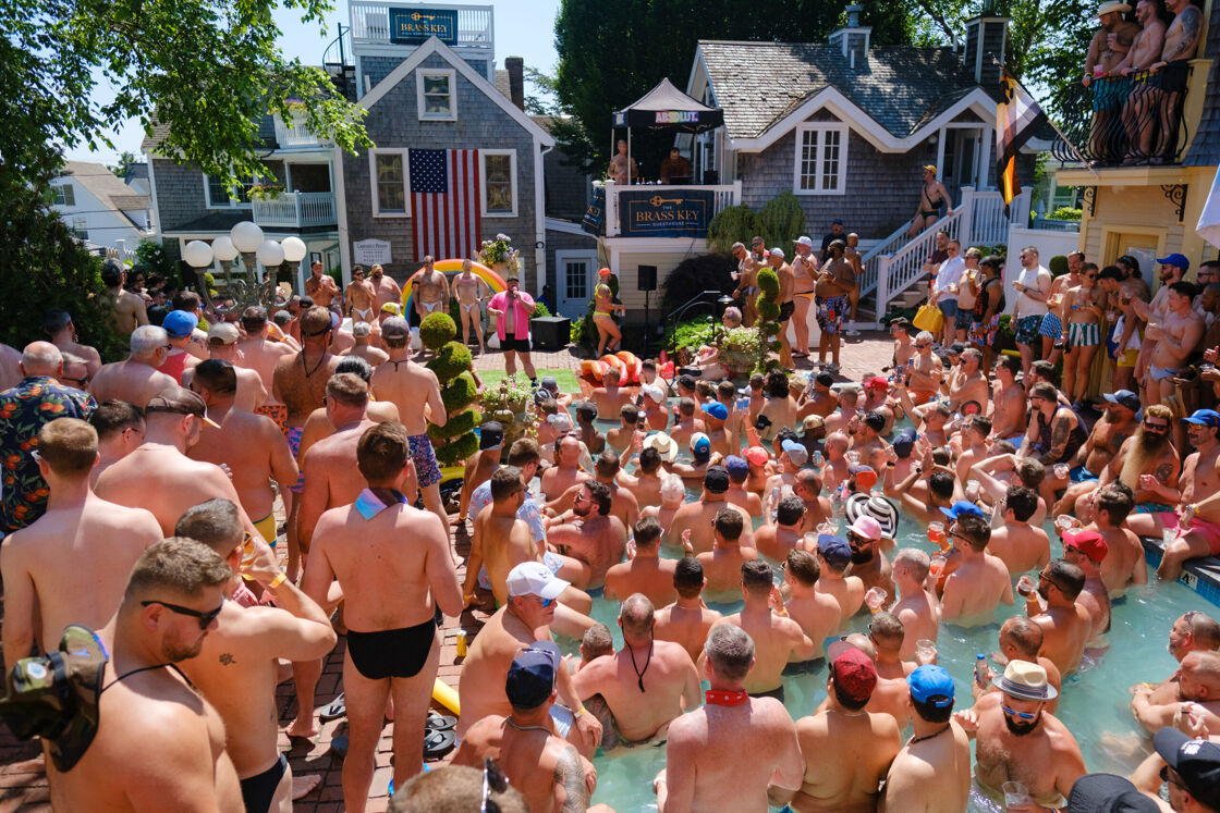 Large crowd of shirtless men at a pool party.