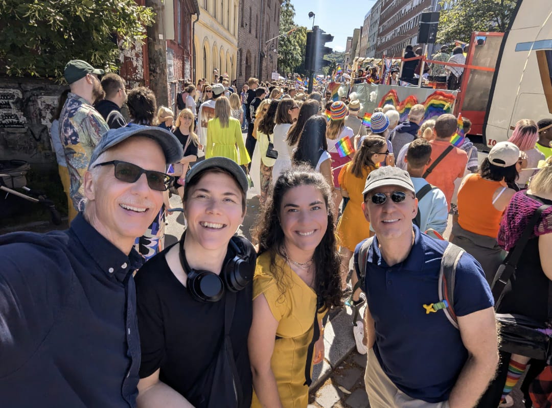 Michael, Marianne, Rinde, and Brent in front of a crowd at Pride The two of us with Marianne and her friend Rinde at Oslo Pride.