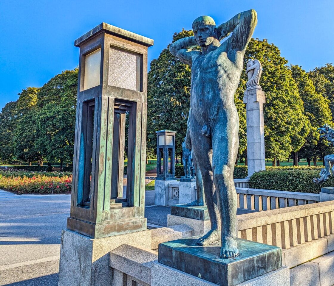 Sculpture of naked man on bridge, hands behind his head as he poses. A statue at Vigeland Sculpture Park
