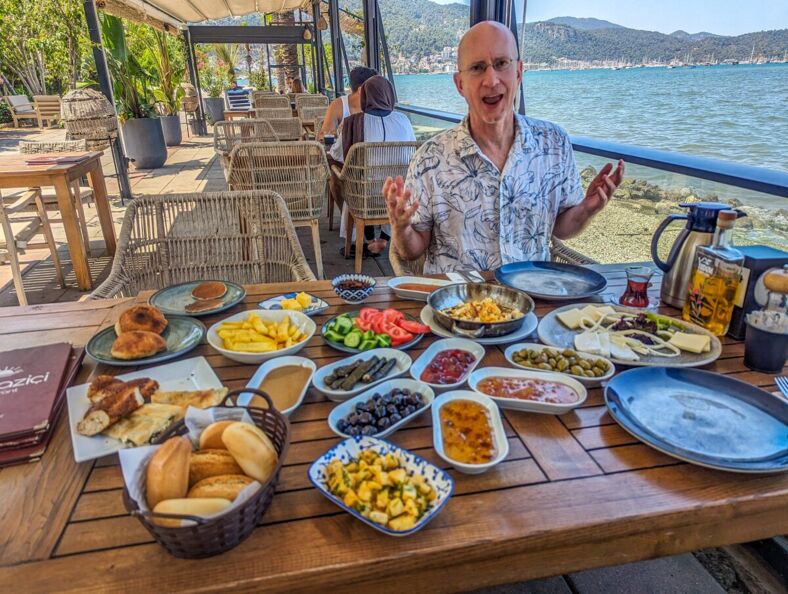 Brent looking amazed by all of the food spread out on the table in front of him.