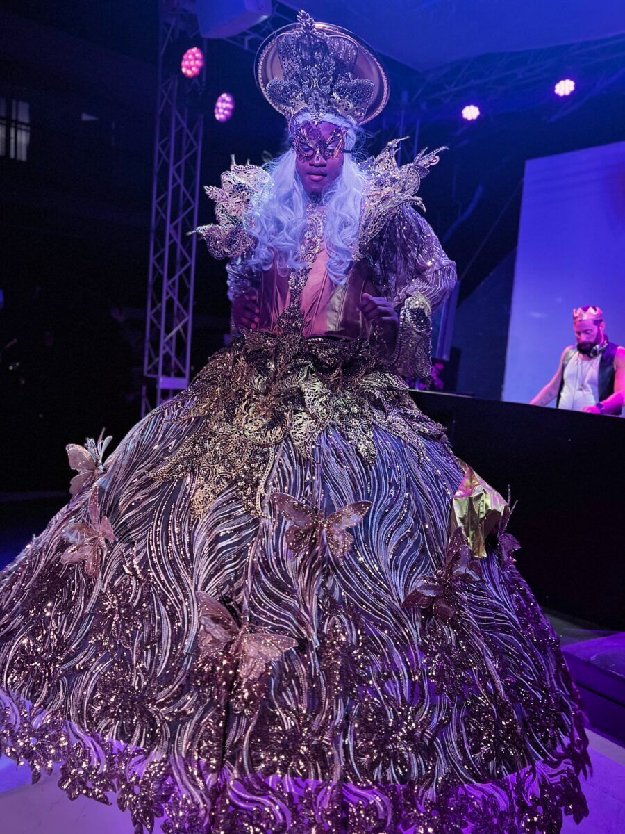 A gorgeous queen in full gold gown regalia takes the catwalk