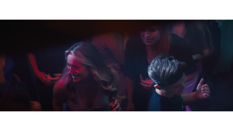 Two women dance on a crowded dancefloor