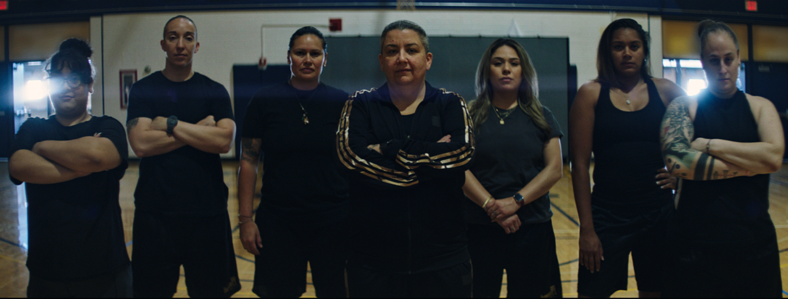 Six women wearing black stare at the camera