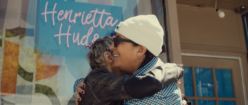 Two women embrace outside of a lesbian bar