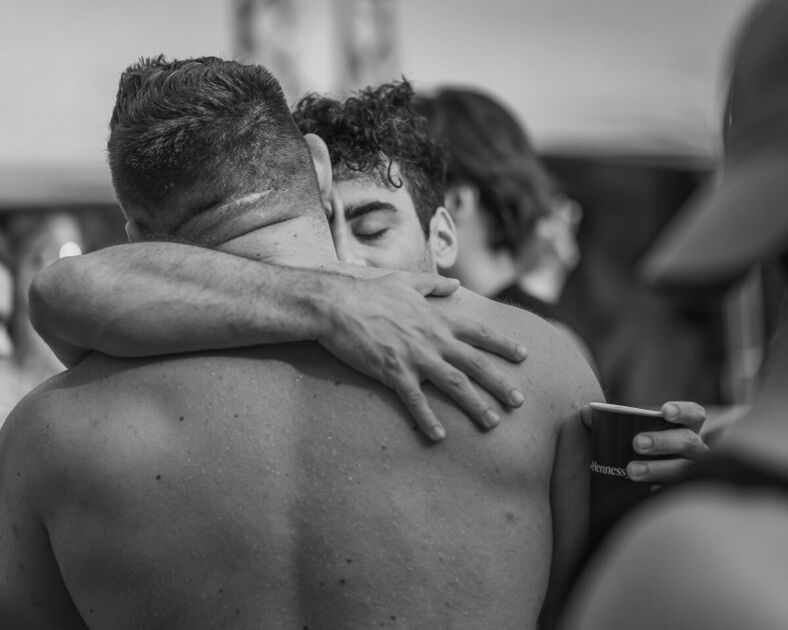 Two men embrace on the dance floor