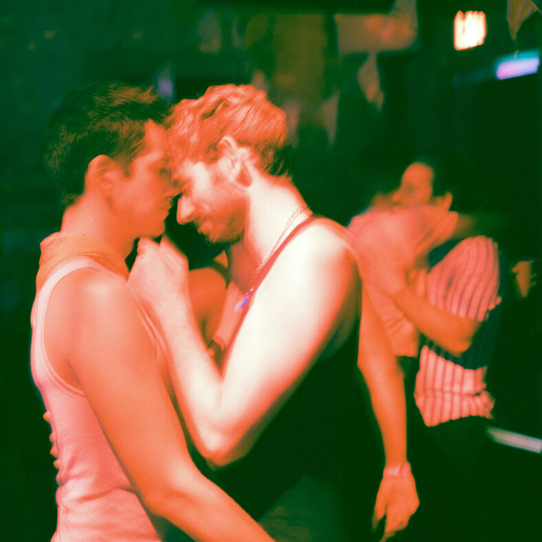 Two men embrace on a dance floor