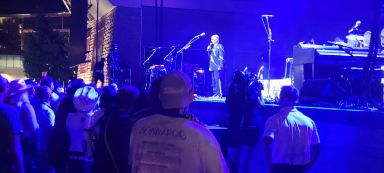 John Waters stands on stage