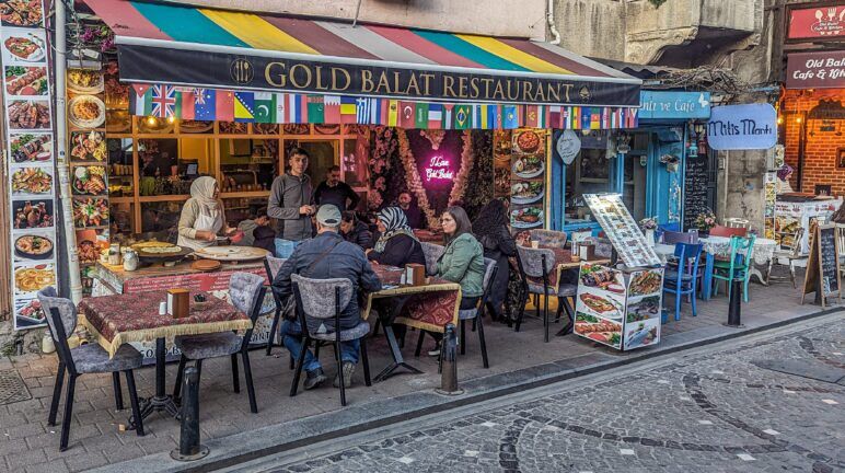 People eating outdoors at the Gold Balat restaurant. Outside view of Gold Balat Restaurant